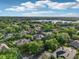 An aerial view highlights the neighborhood, mature landscaping, and a nearby lake at 859 Windcrest Pl, Winter Springs, FL 32708