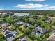 Aerial view of homes in a lush, green neighborhood with swimming pools and a lake at 859 Windcrest Pl, Winter Springs, FL 32708