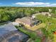 Back aerial view of a home with a pool, patio, lush yard, and three-car garage at 859 Windcrest Pl, Winter Springs, FL 32708