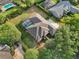 Aerial view of the property showcasing mature trees, a backyard pool, and a screened patio at 859 Windcrest Pl, Winter Springs, FL 32708