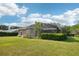 View of the exterior home and backyard with a screen-enclosed pool area and well-maintained lawn at 859 Windcrest Pl, Winter Springs, FL 32708