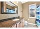 Bathroom features granite countertop, framed mirror, tile flooring and a window at 859 Windcrest Pl, Winter Springs, FL 32708