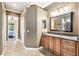 A bathroom showcasing granite counters, wood cabinets, and a large framed mirror at 859 Windcrest Pl, Winter Springs, FL 32708
