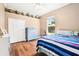 Well-lit bedroom featuring a ceiling fan, wood floors, and a large window with views of the backyard at 859 Windcrest Pl, Winter Springs, FL 32708
