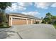 Exterior view of a three-car garage and large driveway, providing ample parking space at 859 Windcrest Pl, Winter Springs, FL 32708