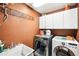 Functional laundry room with modern washer and dryer, white cabinets and a utility sink at 859 Windcrest Pl, Winter Springs, FL 32708