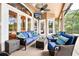 Covered patio with comfortable blue seating, ceiling fan, and views of the pool and garden at 859 Windcrest Pl, Winter Springs, FL 32708