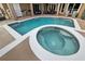 Backyard pool and spa featuring clear blue water, surrounding patio space, and a barbecue at 859 Windcrest Pl, Winter Springs, FL 32708