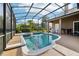 This screened pool and spa area offers a relaxing retreat with tropical landscaping and a built-in outdoor kitchen at 859 Windcrest Pl, Winter Springs, FL 32708
