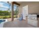 A stainless steel outdoor grill with counter stands ready next to colorful floats near the screened in pool area at 859 Windcrest Pl, Winter Springs, FL 32708