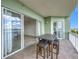 A balcony features a table and stools, sliding glass doors, and waterfront views at 8743 S The Esplanade # 18, Orlando, FL 32836