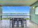 Beautiful balcony space with a table and four chairs, offering serene water views at 8743 S The Esplanade # 18, Orlando, FL 32836