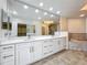 Spacious bathroom with double vanity, tiled bathtub, decorative mirrors, and view into a walk-in closet at 8743 S The Esplanade # 18, Orlando, FL 32836