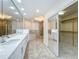 Bathroom with double vanity, tiled bath, walk-in shower and view to walk-in closet at 8743 S The Esplanade # 18, Orlando, FL 32836