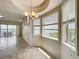 Living area with large windows providing water views, complemented by a contemporary chandelier and neutral decor at 8743 S The Esplanade # 18, Orlando, FL 32836