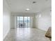 Bright, open living room with tile flooring and sliding glass doors leading to a balcony overlooking the water at 8743 S The Esplanade # 18, Orlando, FL 32836