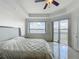 Tranquil primary bedroom showcasing tray ceilings, tile flooring, and water views from the windows at 8743 S The Esplanade # 18, Orlando, FL 32836