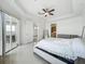 Luxurious primary bedroom featuring tray ceilings, tile flooring, and access to a private balcony at 8743 S The Esplanade # 18, Orlando, FL 32836