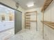Bright walk-in closet boasting custom wooden shelving and drawers, adjacent to a bathroom with a sleek, modern vanity at 8743 S The Esplanade # 18, Orlando, FL 32836