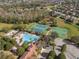 The aerial perspective displays a community's recreational amenities: a pool, tennis, and basketball courts nestled amidst trees at 920 Nola Dr, Ocoee, FL 34761