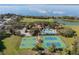 An aerial shot reveals a community hub with a sparkling pool, tennis, and basketball courts near a serene lake at 920 Nola Dr, Ocoee, FL 34761