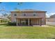 A rear exterior view showcasing a covered patio and a spacious backyard lawn area at 920 Nola Dr, Ocoee, FL 34761