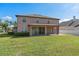The home's rear exterior features a covered patio and expansive green lawn, ideal for relaxation and outdoor activities at 920 Nola Dr, Ocoee, FL 34761