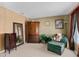 Cozy bedroom seating area with upholstered chair and ottoman, accented by elegant wood furniture and decor at 920 Nola Dr, Ocoee, FL 34761