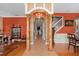 Grand foyer with decorative columns and archway, complemented by hardwood floors and terracotta-colored walls at 920 Nola Dr, Ocoee, FL 34761