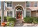 Elegant arched entryway with double doors and manicured landscaping at 920 Nola Dr, Ocoee, FL 34761