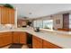 Well-equipped kitchen with wooden cabinets, stainless appliances, and breakfast bar overlooking living area at 920 Nola Dr, Ocoee, FL 34761
