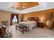 Comfortable main bedroom featuring warm tones, a tray ceiling, and ample natural light at 920 Nola Dr, Ocoee, FL 34761