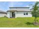 Exterior view of the backyard featuring a well maintained lawn, young tree, and covered patio at 4532 Windy Oak Way, St Cloud, FL 34772