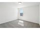 Bedroom with neutral carpet, a window, and minimalist white walls bathed in sunlight at 4532 Windy Oak Way, St Cloud, FL 34772
