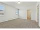 Bedroom with neutral carpet, white walls, large windows, and a doorway to an adjacent room at 4532 Windy Oak Way, St Cloud, FL 34772