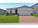 Charming single Gathering home featuring an attached two-car garage and brick-paved driveway at 4532 Windy Oak Way, St Cloud, FL 34772