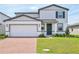 Charming two-story home with a brick driveway, manicured lawn, and a modern color scheme at 4532 Windy Oak Way, St Cloud, FL 34772