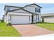 Beautiful two-story home featuring a brick driveway, attached garage and manicured front lawn at 4532 Windy Oak Way, St Cloud, FL 34772