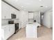 Modern white kitchen features stainless appliances, central island, and ample cabinet space at 4532 Windy Oak Way, St Cloud, FL 34772