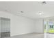 Bright living room featuring light wood-look flooring and sliding glass doors to the backyard at 4532 Windy Oak Way, St Cloud, FL 34772