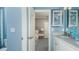 En suite bathroom with white cabinets, blue accents, and a view of the bedroom at 4716 Coral Harbour Rd, Kissimmee, FL 34758