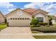 Charming single-story home features a paver driveway, lush landscaping and a neutral-toned garage door at 618 Via Milano, Apopka, FL 32712