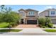 Charming two-story home featuring a brick driveway, a two-car garage, and beautiful landscaping at 7392 Marker Ave, Kissimmee, FL 34747