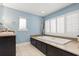 Luxurious bathroom featuring a soaking tub with plantation shutters for natural light and privacy at 7849 Georgeann St, Winter Park, FL 32792