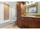 Neutral bathroom with modern vanity, mosaic tile accents, and shower-tub combination at 7849 Georgeann St, Winter Park, FL 32792