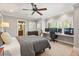 Comfortable bedroom with an integrated desk, ceiling fan, and view to the ensuite bath at 7849 Georgeann St, Winter Park, FL 32792