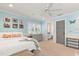 Comfortable bedroom with a ceiling fan, shutters, a side table, and a door to the bathroom at 7849 Georgeann St, Winter Park, FL 32792