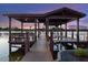 Covered boat dock with seating, offering stunning waterfront views and a relaxing atmosphere at 7849 Georgeann St, Winter Park, FL 32792