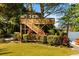 Exterior view of custom treehouse featuring a deck, stairs and lush landscaping at 7849 Georgeann St, Winter Park, FL 32792