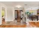 Bright foyer featuring a wood door, tile floor, and an open view to the dining room at 7849 Georgeann St, Winter Park, FL 32792